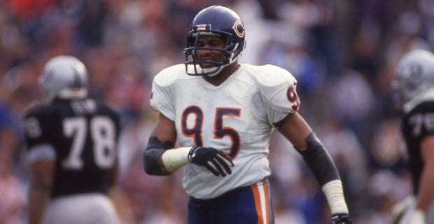 Chicago Bears' Richard Dent carries the Super Bowl Trophy as the